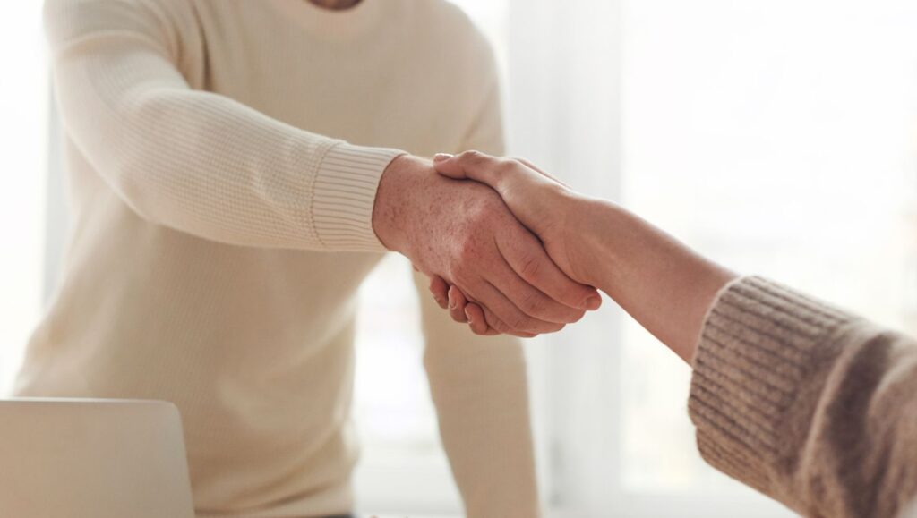 Two individuals shaking hands, symbolizing connection and collaboration.